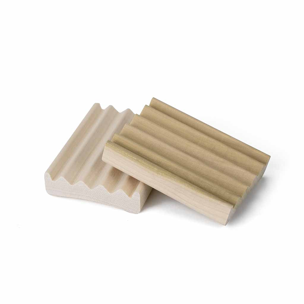 Two wooden soapdishes with grooves, one beige and one light brown, placed on a white background.