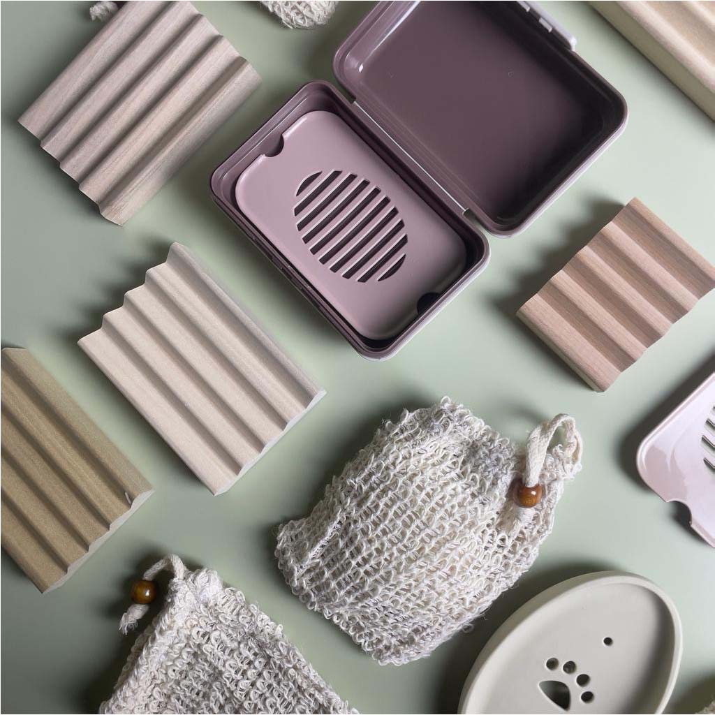 Don Gato natural soap accessories collection banner. Wooden soap dishes, eco-friendly soap saver bags, and reusable plastic travel soap boxes displayed on a soft green background