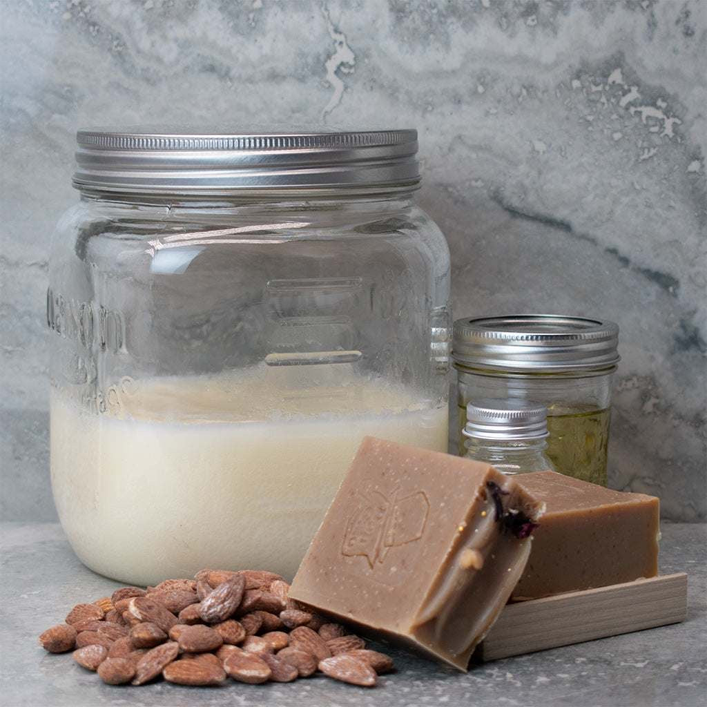 Almond Artisan Soap with almonds, butter, and oil jars. Sweet almond and cherry scent.
