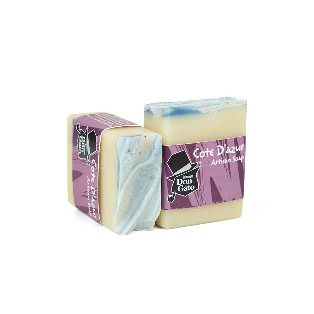 Cote d’Azur artisan soap by Jabonera Don Gato from the Bestsellers collection, wrapped in purple label with brand logo and blue swirled top on white background.
