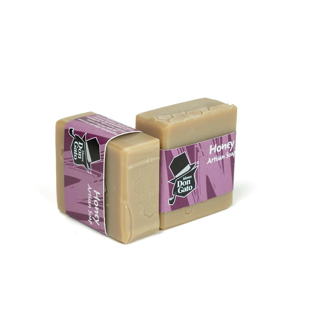 Honey artisan soap by Jabonera Don Gato from the Bestsellers collection, wrapped in purple label with brand logo and subtle honeycomb texture on white background.
