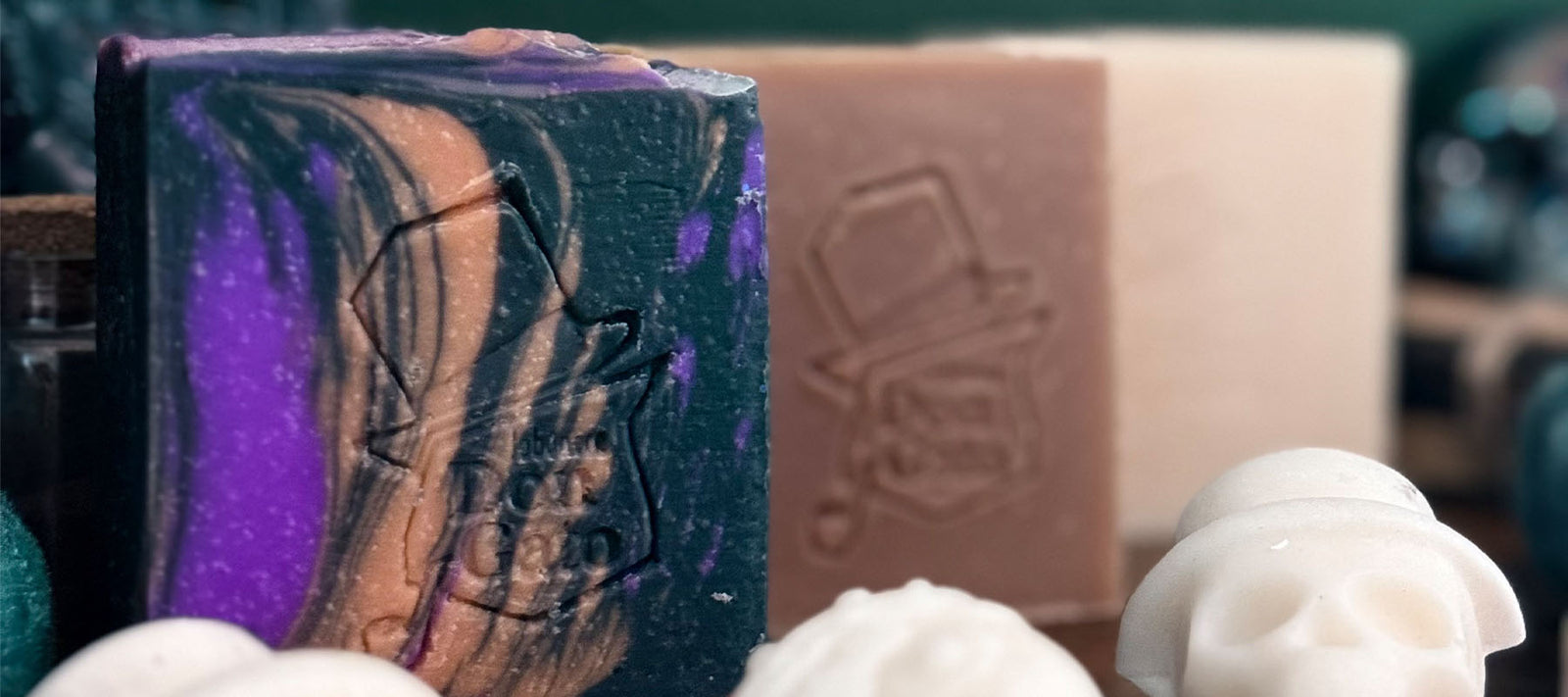 The Witching Hour Artisan Soap collection horizontal cover — purple and copper swirled soap with embossed Don Gato label, accompanied by natural soaps and decorative skulls on a dark surface.